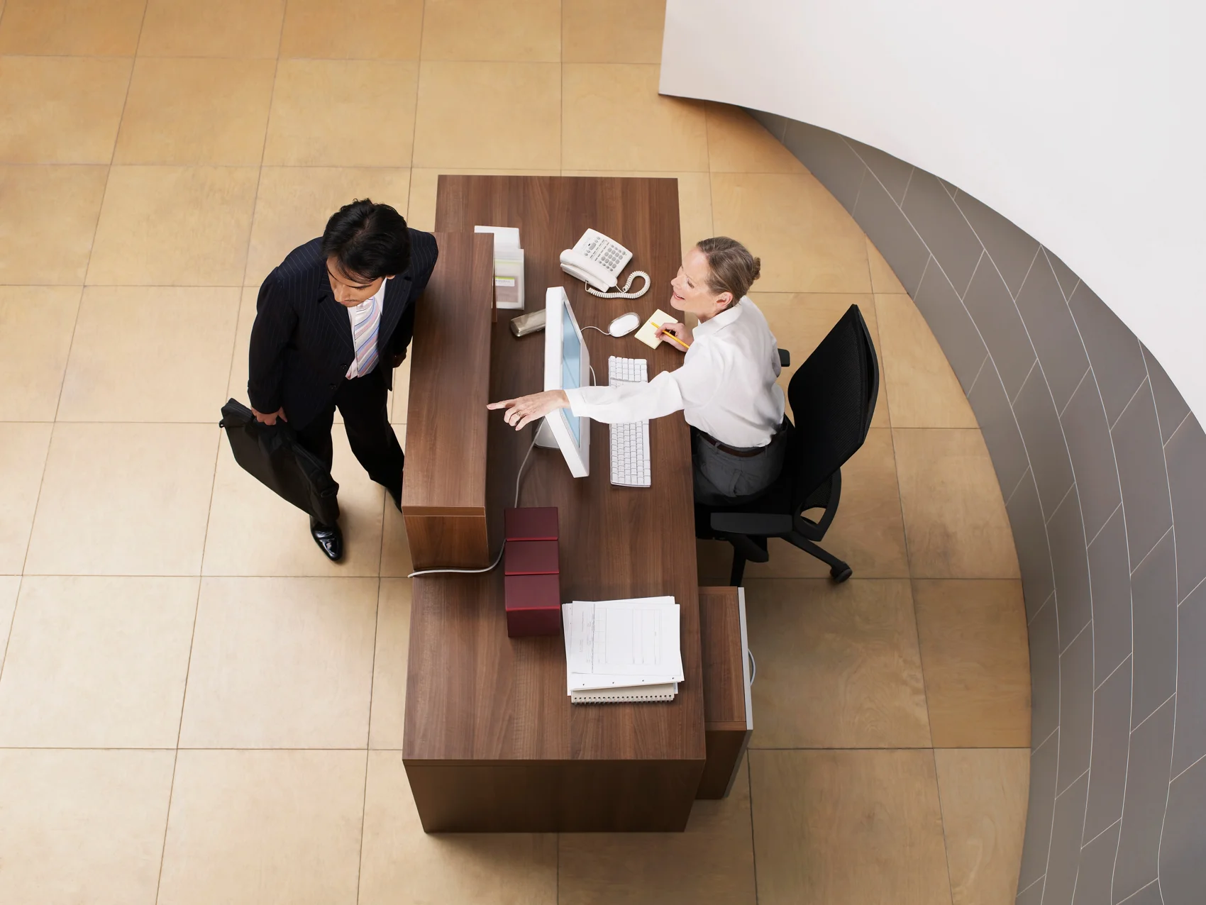 Woman helping a client at a reception desk